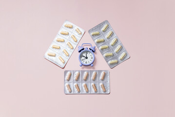 Blister Packages with Capsules and Alarm Clock Showing Concept of Taking Medicine on Time or Managing Health Schedule.
