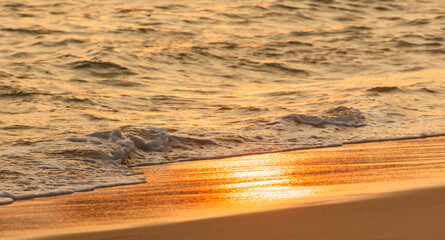 The ocean is calm and the sun is setting, creating a beautiful