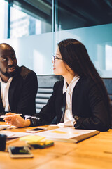 Diverse male and female colleagues discussing business exchange during working day in corporate...
