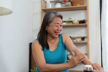 Beauty and Wellness. A joyful elderly woman applying cream to her arm, celebrating self-care.