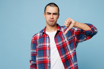 Young sad disappointed displeased middle eastern man he wear red shirt casual clothes showing thumb...