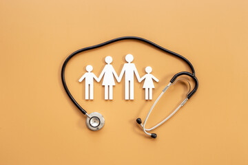 Family wooden figure with medical stethoscope - health care and insurance concept. top view