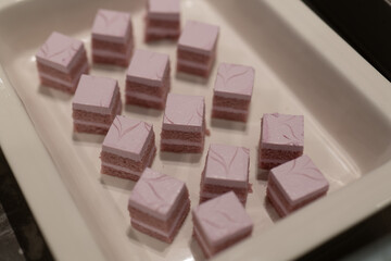 Delicate Pink and Purple Cubes of Sweet Dessert on White Plate