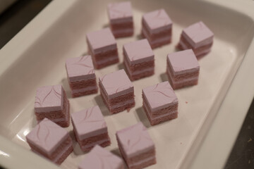 Delicate Pink and Purple Cubes of Sweet Dessert on White Plate