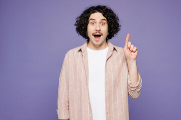 Young surprised brunet man he wears pink shirt t-shirt casual clothes holding index finger up with great new idea isolated on plain pastel light purple background studio portrait. Lifestyle concept.