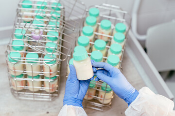 High angle view of open freezer drawer filled with labeled bottles of donor breast milk