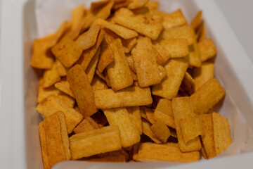 Golden Crispy Snacks in White Container, Perfect for Snacking