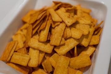 Golden Crispy Snacks in White Container, Perfect for Snacking