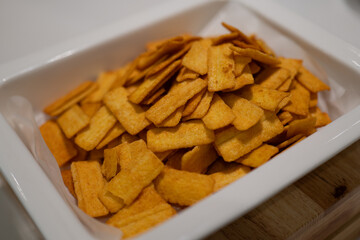 Golden Crispy Snacks in White Container, Perfect for Snacking