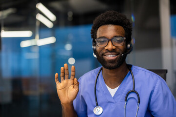 A smiling healthcare professional wearing a headset waves hello, seemingly ready to assist. The doctor sports glasses and a stethoscope.