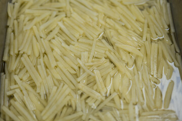 Freshly Shredded Potatoes Soaked in Water for Cooking Preparation