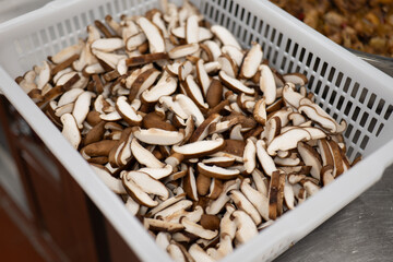 Sliced Shiitake Mushrooms in White Plastic Basket Showing Fresh Texture