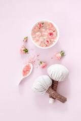 Spa and beauty routine concept with pink roses and essence water with petals