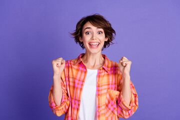 Portrait of nice young lady raise fist wear shirt isolated on purple color background