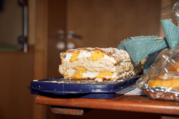 Delicious tiramisu dessert slice on table with powdered sugar