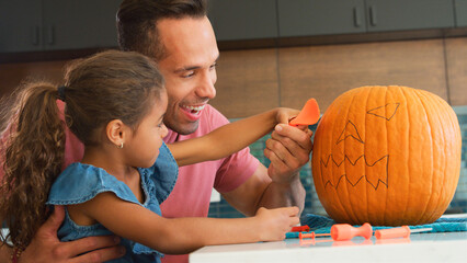 Fototapeta premium Father And Daughter Carving Halloween Lantern From Pumpkin At Home
