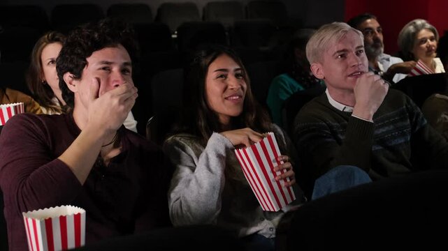 Audience reacting to a suspenseful scene in a movie theater