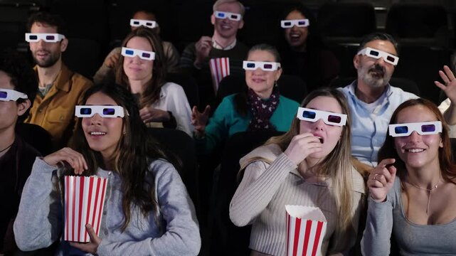 Audience wearing 3d glasses enjoying movie and eating popcorn - Powered by Adobe
