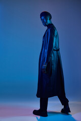 Stylish young man in blue and purple lighting makes a bold visual statement
