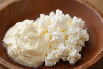 Ricotta cheese, cottage cheese farmers cheese, curd or tvorog in a wooden bowl
