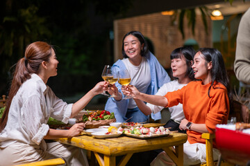 A group of women are sitting around a table, enjoying a meal