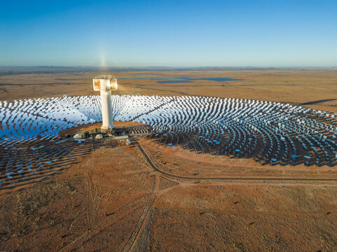 Solar rays reflect off grid of mirrors onto concentrated solar tower in Kalahari desert near Upington, South Africa