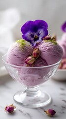 Delightful lavender ice cream served in a glass bowl with edible flowers and pistachio garnish on a marble countertop