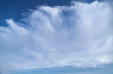 Naklejka premium Large cirrus clouds in the sky during sunny weather, close-up, cloudy background, cloud texture on the blue sky.