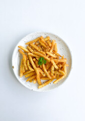 Tasty French fries on a plate, on a white background