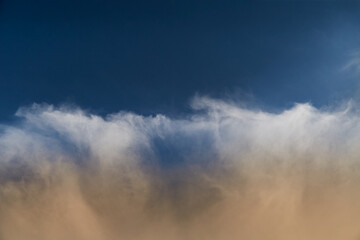 Cirrus clouds in the warm sunlight against the blue sky in clear weather, close-up, cloudy...