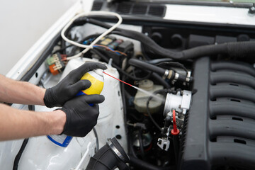 Spraying Throttle Valve Cleaner in a Car Engine for Effective Maintenance and Improved Performance