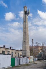 A large tall brick chimney from the boiler room venting smoke while burning coal to heat homes became the city tower for cell phone equipment