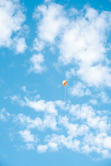 A yellow ball in the shape of a star flies in the blue sky