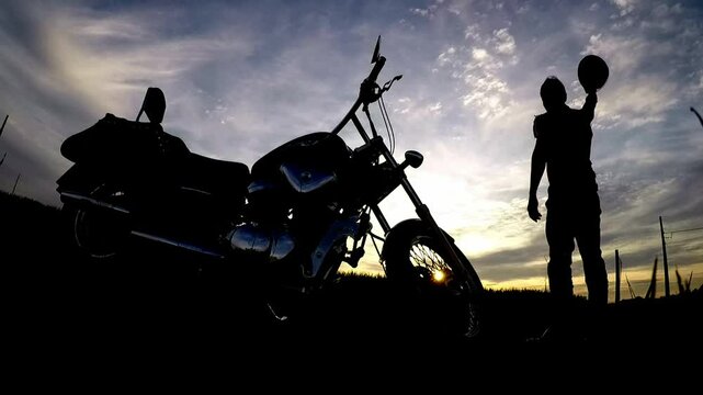 silhueta de motoqueiro na estrada 