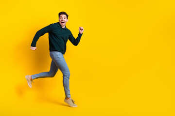 Fototapeta na wymiar Happy young man in casual outfit running joyfully against yellow background, expressing positivity and a modern lifestyle