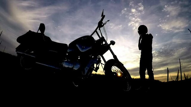 silhueta de motoqueiro na estrada 