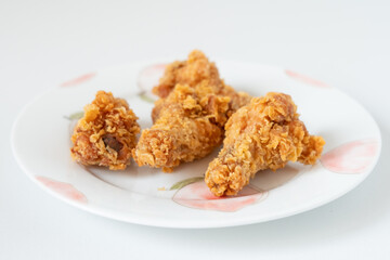 Asian Chinese food style 4 deep fried spicy chicken wings gourmet snacks on a ceramic plate, close up on white background