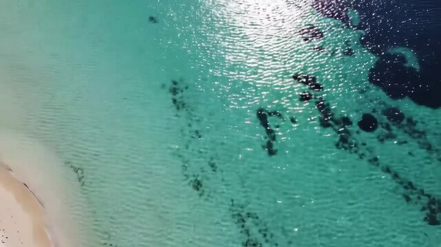 Aerial View of Pristine Tropical Beach with Crystal Clear Waters and Sandy Shoreline, Featuring Natural Patterns in the Shallow Depths
