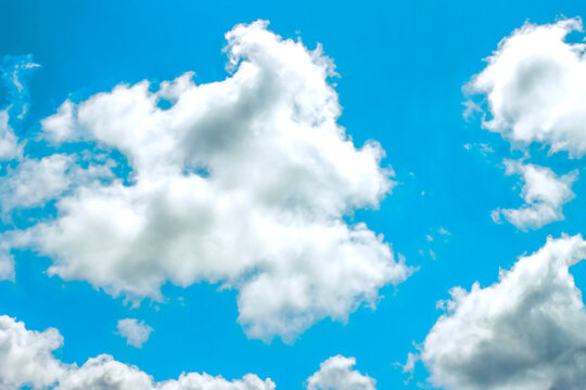 Fluffy white clouds in a bright blue sky on a sunny day