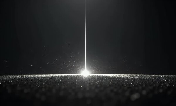 A beam of light shines on the ground, with a black background and particles floating in front of it. The beam is extremely thin, with white particle effects around its edges.