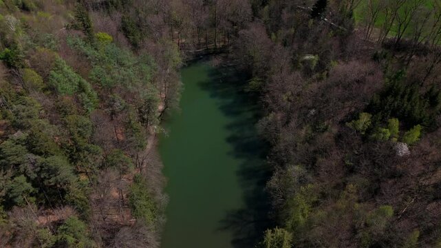 Stunning aerial view of Spiegelweiher serene lake chain near Grafing bei Muenchen, Bavaria, Deutschland. Crystal clear waters, lush spring greenery and trails create perfect scene for nature lovers. 