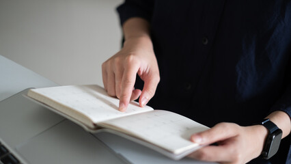 Close-up business person holding calendar on note pad reminder office event document planning time management concept