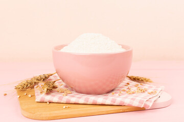 Bowl with spelt flour on wooden table