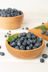 Bowl with fresh blueberries on wooden table