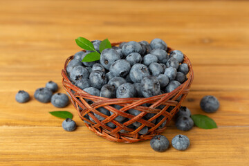 Bowl with fresh blueberries on wooden table
