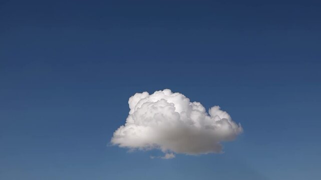 A single fluffy white cloud floats peacefully against a clear blue sky, evoking a sense of serenity, tranquility, and calmness in the vast expanse above.