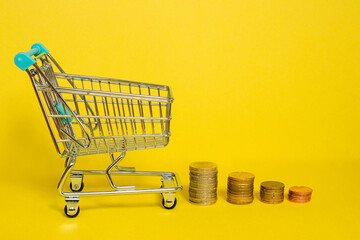 A miniature shopping cart filled with coins, symbolizing savings, investment, and financial growth....