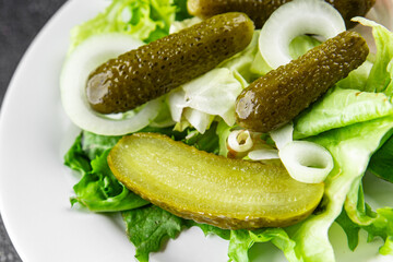 Pickle salad gherkins pickled cucumbers mixed green leaf lettuce appetizer vegetables dish organic fresh tasty gourmet food background on the table food top view copy space vegetarian vegan food