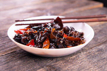 Wood ear mushrooms with vegetables on dark background. vegan food