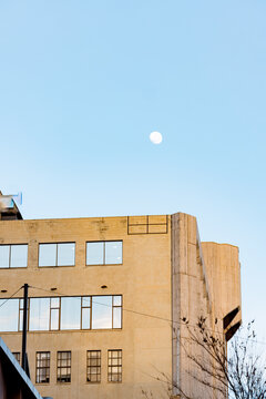 Moon visible in the daytime above tall buildings in Adelaide